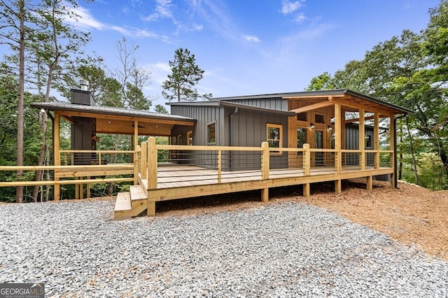 rear view of house with a chimney, a deck, and board and batten siding