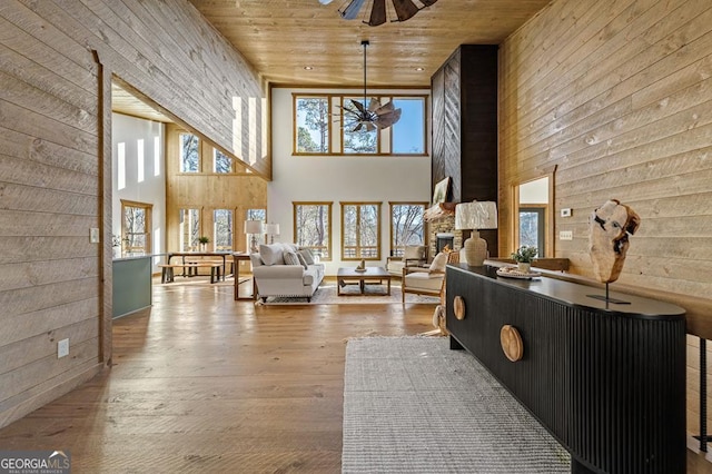 living area featuring a ceiling fan, wood ceiling, and a high ceiling
