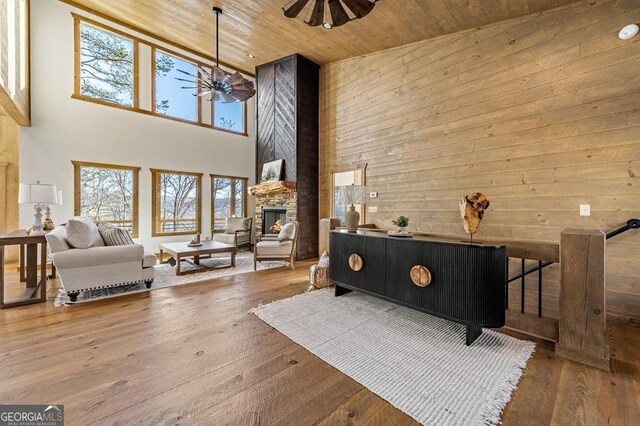 interior space featuring wooden ceiling, a towering ceiling, a healthy amount of sunlight, and ceiling fan with notable chandelier