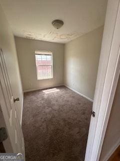 spare room with baseboards and carpet flooring