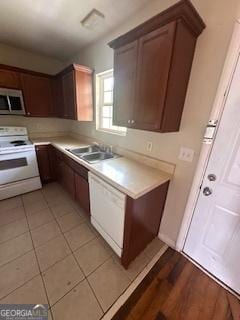 kitchen featuring a sink, light countertops, and white range with electric cooktop