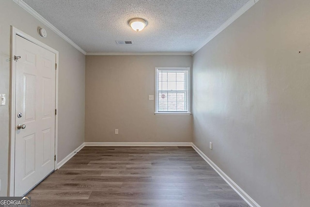 4089 Lindsey Dr, Decatur, GA 30035 - spare room with wood finished floors, a textured ceiling, visible vents, crown molding, and baseboards