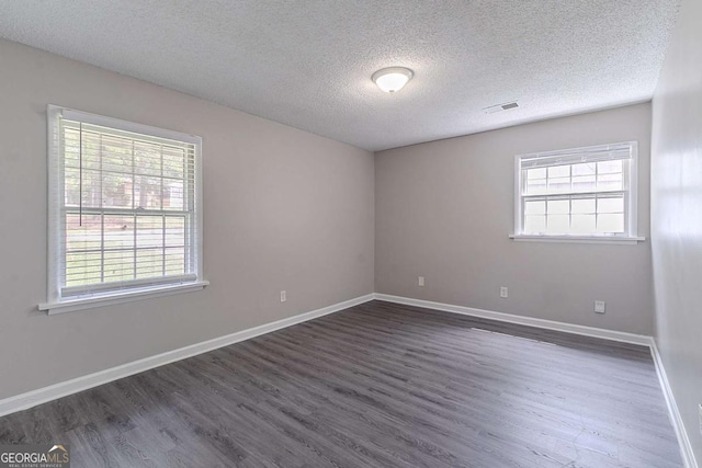 4089 Lindsey Dr, Decatur, GA 30035 - empty room featuring a textured ceiling, visible vents, dark wood-style flooring, and a healthy amount of sunlight