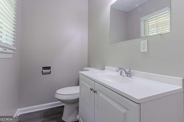 4089 Lindsey Dr, Decatur, GA 30035 - half bath featuring vanity, toilet, baseboards, and wood finished floors