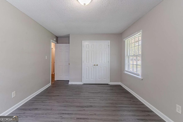 4089 Lindsey Dr, Decatur, GA 30035 - unfurnished bedroom featuring dark wood finished floors, a closet, a textured ceiling, and baseboards