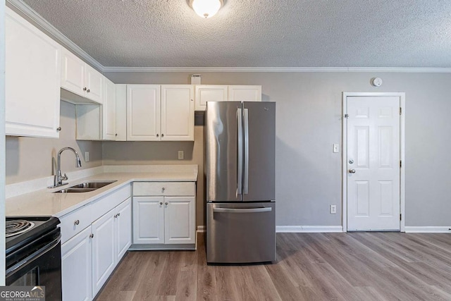 4089 Lindsey Dr, Decatur, GA 30035 - kitchen featuring freestanding refrigerator, a textured ceiling, a sink, wood finished floors, and black electric range