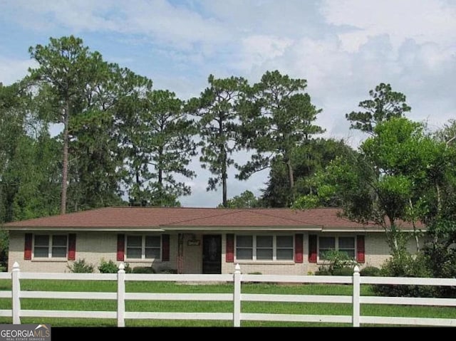 single story home featuring a front lawn, a fenced front yard, and brick siding