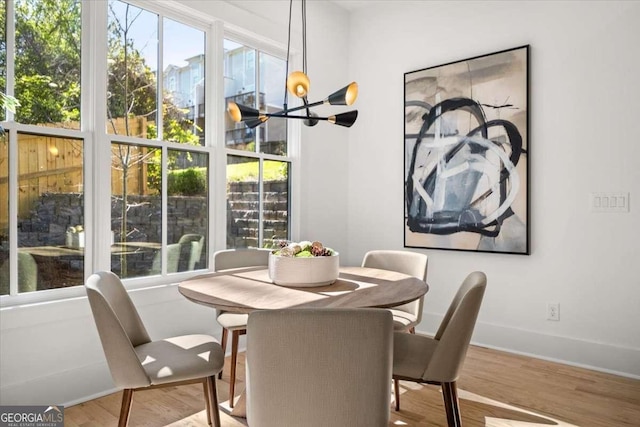 dining space with a notable chandelier, baseboards, and wood finished floors