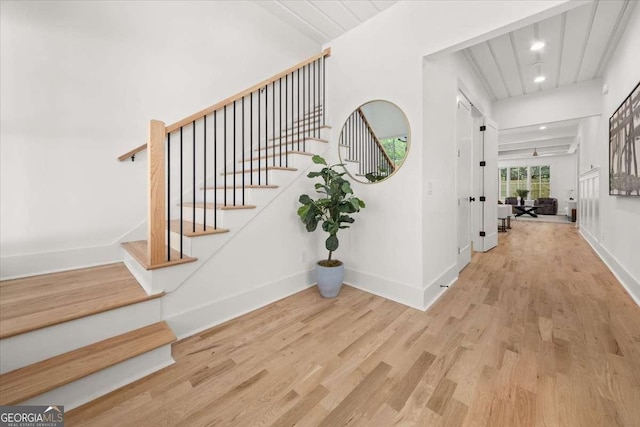stairway featuring wood finished floors, baseboards, and recessed lighting