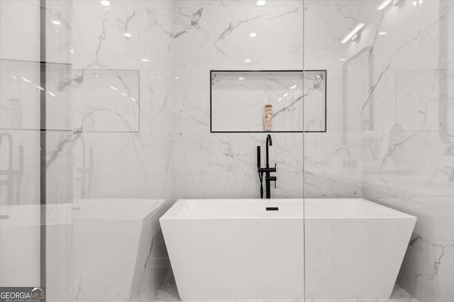 full bath featuring tile walls and a freestanding bath