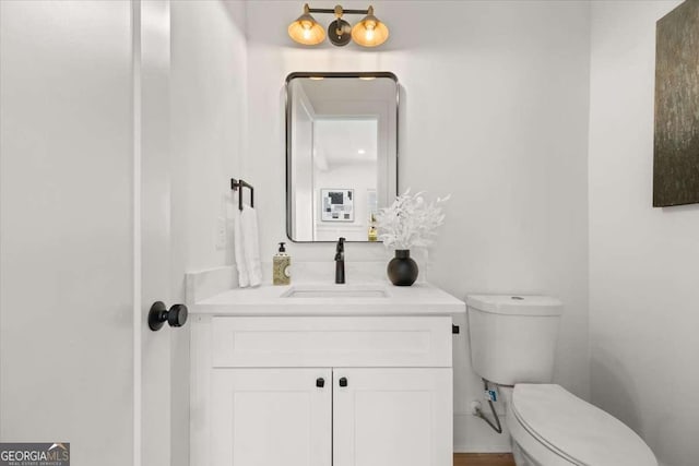 half bathroom featuring vanity and toilet