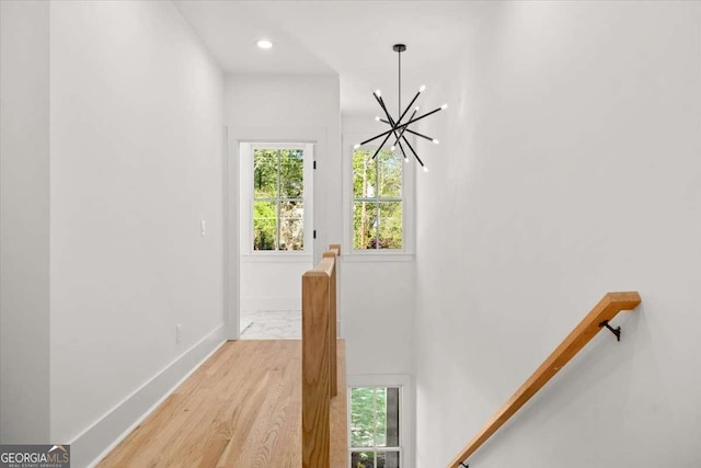 doorway with baseboards, recessed lighting, a chandelier, and light wood-type flooring