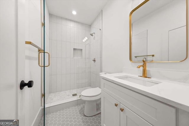 bathroom with tile patterned floors, vanity, toilet, and a shower stall