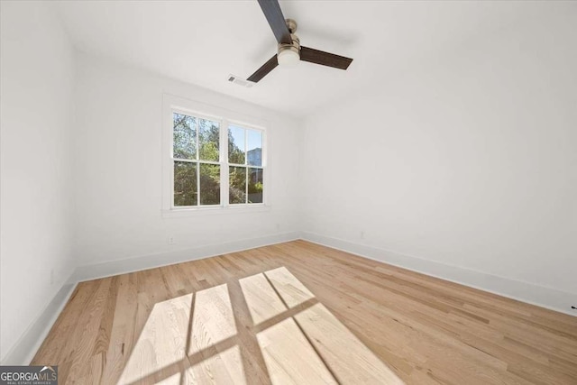 empty room with ceiling fan, baseboards, and wood finished floors