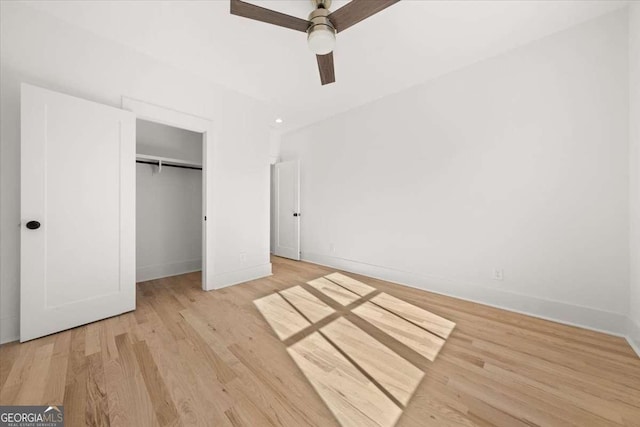 unfurnished bedroom with ceiling fan, baseboards, a closet, and wood finished floors