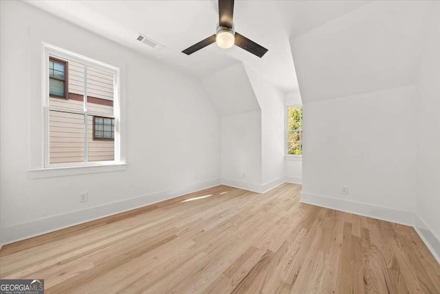 bonus room with vaulted ceiling, baseboards, visible vents, and wood finished floors