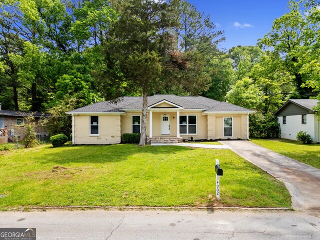 ranch-style home with fence, a front lawn, and driveway