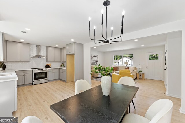dining space with light wood finished floors, a chandelier, visible vents, and recessed lighting