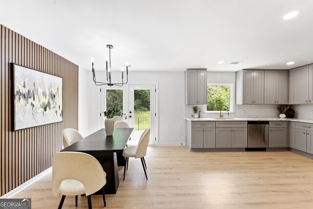 dining room featuring a healthy amount of sunlight, an inviting chandelier, and light wood finished floors