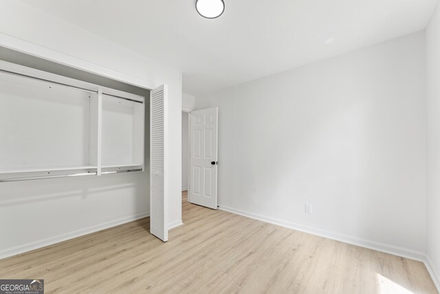 unfurnished bedroom featuring wood finished floors and baseboards