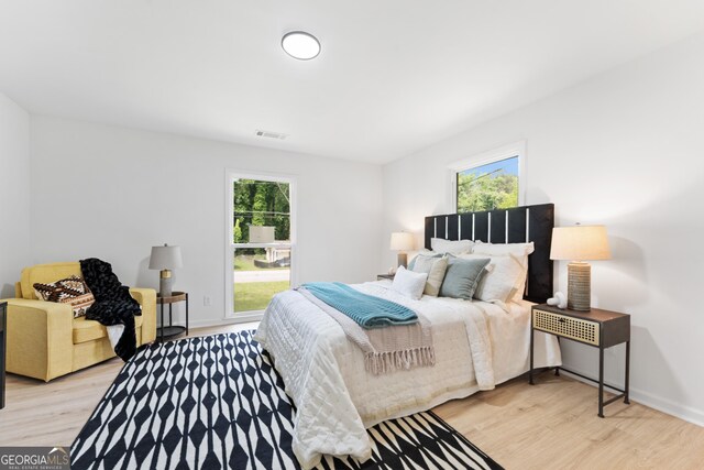 bedroom featuring light wood-style flooring, baseboards, and visible vents