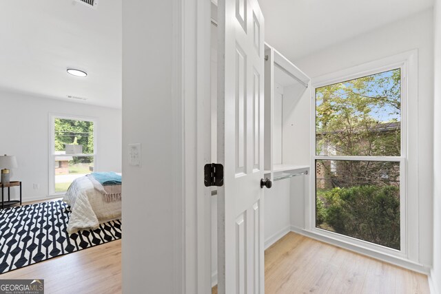 hallway featuring light wood finished floors and visible vents