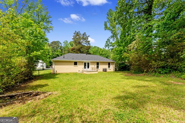rear view of property featuring a yard and stucco siding