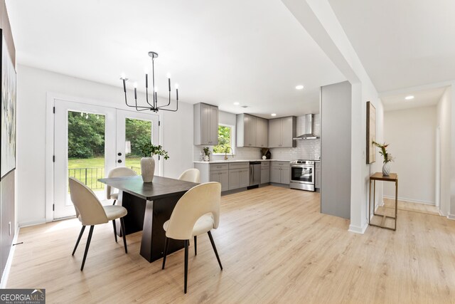 dining space with french doors, recessed lighting, baseboards, an inviting chandelier, and light wood-type flooring