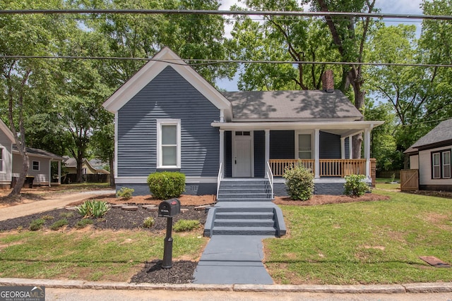 31 Saint Clair St, Newnan, GA 30263 - bungalow featuring covered porch, a front yard, crawl space, and a chimney