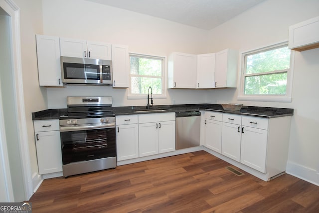 31 Saint Clair St, Newnan, GA 30263 - kitchen featuring stainless steel appliances, a sink, dark wood-type flooring, and white cabinetry