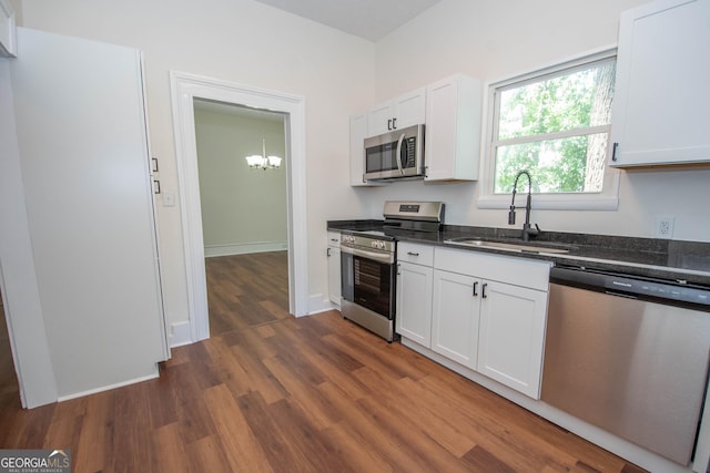 31 Saint Clair St, Newnan, GA 30263 - kitchen with stainless steel appliances, a sink, dark wood finished floors, a chandelier, and white cabinets