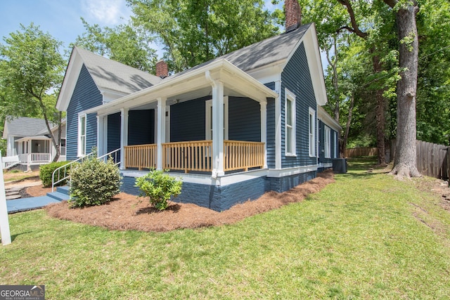 31 Saint Clair St, Newnan, GA 30263 - view of front facade featuring a chimney, a porch, central AC, and a shingled roof
