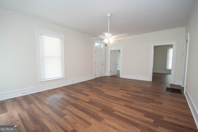 31 Saint Clair St, Newnan, GA 30263 - spare room featuring dark wood-type flooring, crown molding, baseboards, a ceiling fan, and healthy amount of natural light