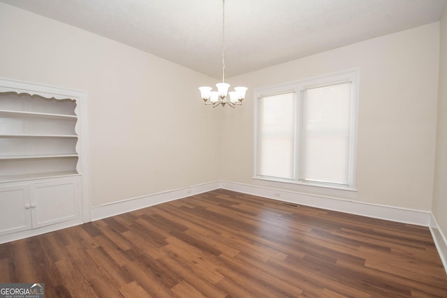 31 Saint Clair St, Newnan, GA 30263 - empty room featuring a chandelier, dark wood-type flooring, and baseboards