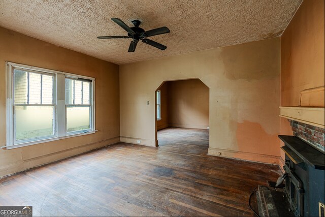 1388 Metropolitan Ave SE, Atlanta, GA 30316 - unfurnished living room featuring wood finished floors, a textured ceiling, baseboards, ceiling fan, and arched walkways