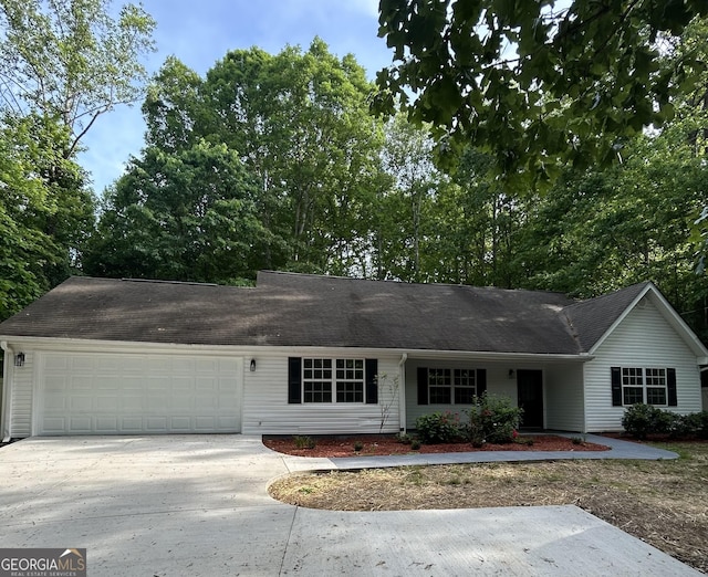 single story home featuring concrete driveway, a shingled roof, and a garage
