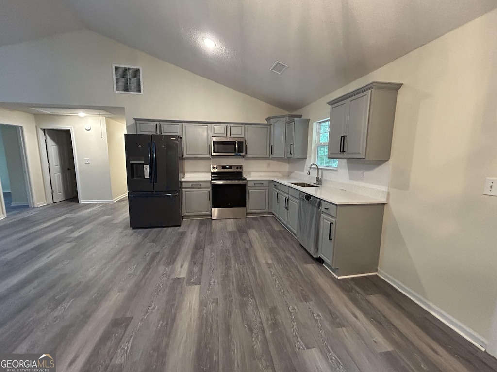 kitchen with a sink, visible vents, baseboards, gray cabinetry, and appliances with stainless steel finishes