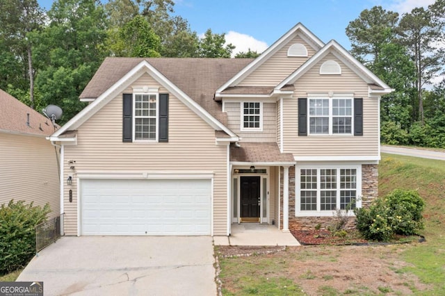 traditional-style house featuring driveway, stone siding, a garage, and roof with shingles