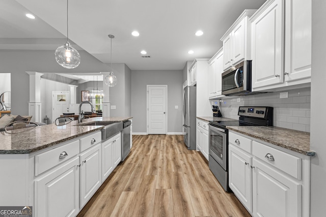88 Carl Williams Rd, Senoia, GA 30276 - kitchen featuring appliances with stainless steel finishes, a sink, white cabinets, tasteful backsplash, and light wood finished floors
