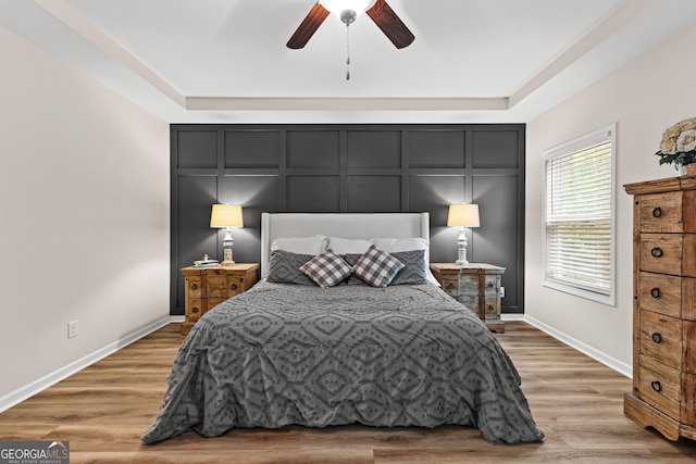 88 Carl Williams Rd, Senoia, GA 30276 - bedroom with baseboards, light wood-style flooring, a ceiling fan, and a decorative wall