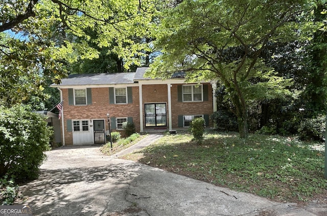 split foyer home with concrete driveway and brick siding