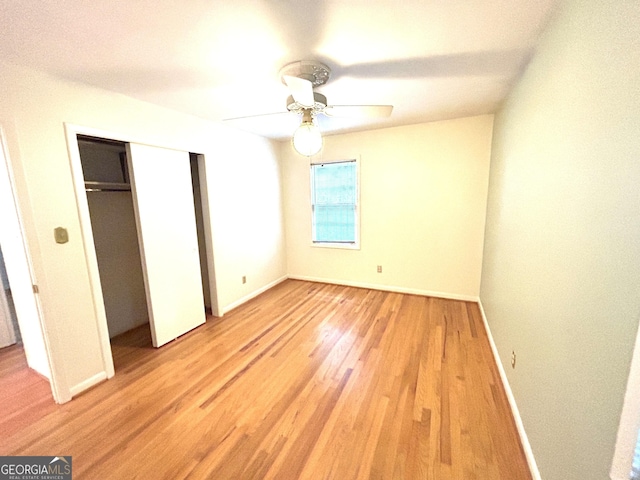 unfurnished bedroom featuring baseboards, a closet, light wood-type flooring, and a ceiling fan