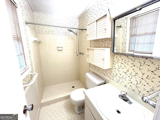 full bathroom with toilet, a tile shower, wallpapered walls, tile patterned flooring, and vanity