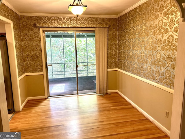 interior space featuring wood finished floors, ornamental molding, wainscoting, baseboards, and wallpapered walls