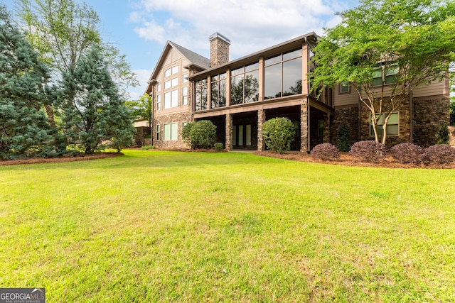 350 Greystone Dr, Milledgeville, GA 31061 - rear view of house with stone siding, a sunroom, a yard, and a chimney