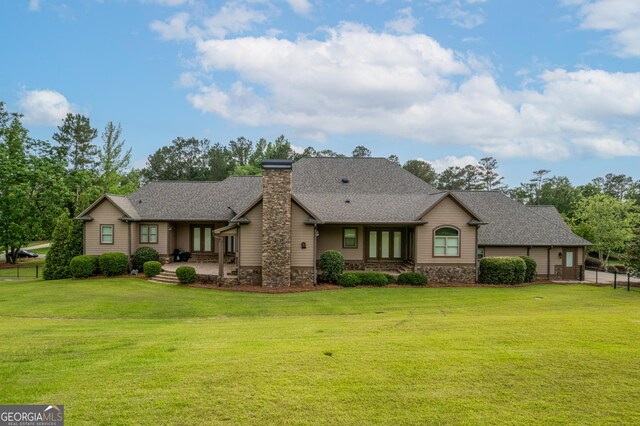 350 Greystone Dr, Milledgeville, GA 31061 - view of front of home with a chimney, a front yard, stone siding, and fence