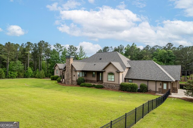350 Greystone Dr, Milledgeville, GA 31061 - view of front of house featuring fence, a shingled roof, a front lawn, and a chimney