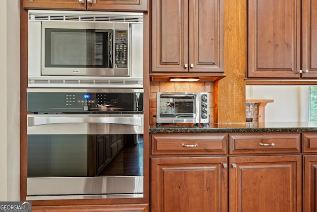 350 Greystone Dr, Milledgeville, GA 31061 - kitchen with brown cabinets, a toaster, dark stone counters, and appliances with stainless steel finishes