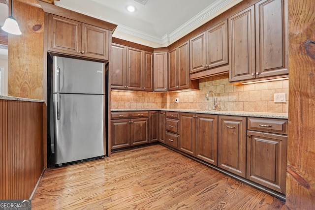 350 Greystone Dr, Milledgeville, GA 31061 - kitchen with a sink, freestanding refrigerator, ornamental molding, light wood-type flooring, and light stone counters