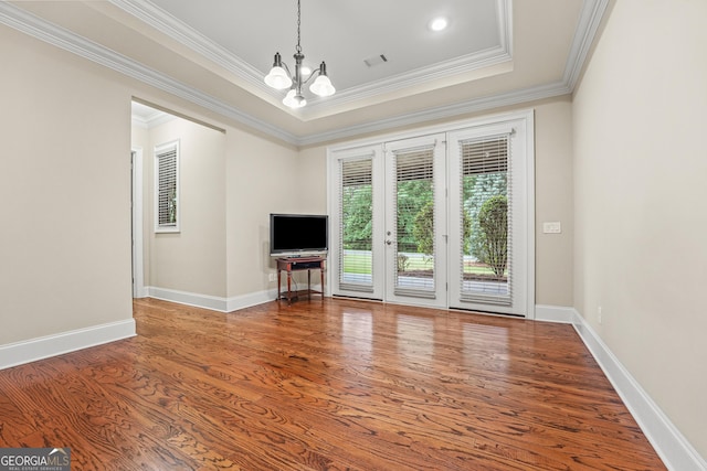 350 Greystone Dr, Milledgeville, GA 31061 - unfurnished living room with an inviting chandelier, wood finished floors, baseboards, a raised ceiling, and ornamental molding